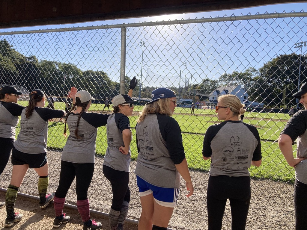 Honey Badgers high-fiving by the dugout fence