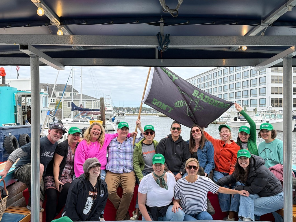Honey Badgers team on a harbor boat cruise with their flag