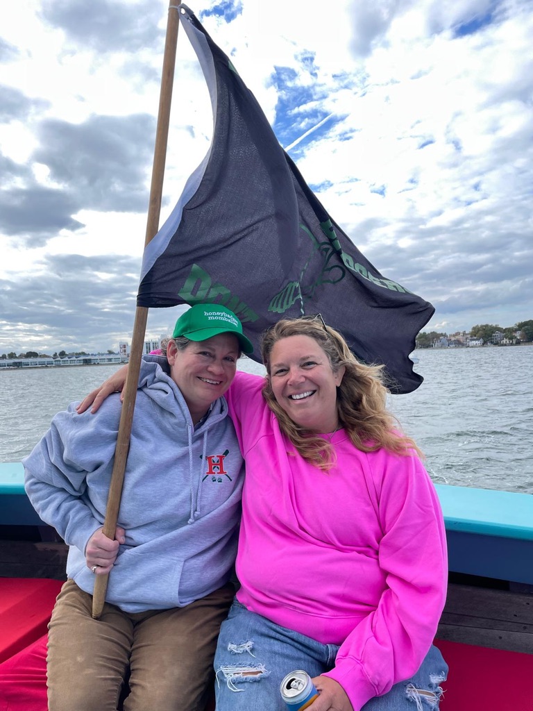 Two teammates with the Honey Badgers flag on the water