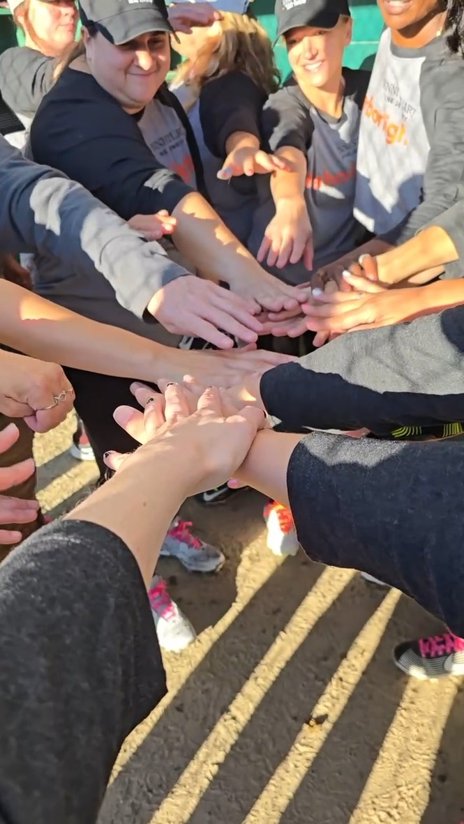 Hands stacked in the middle of a team huddle